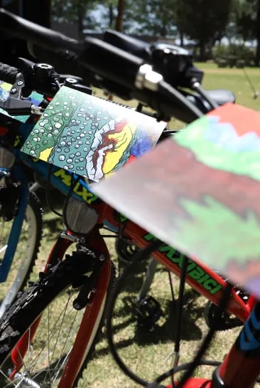 An image of the bicycle delivery as part of the children's educational program "Racimo de Colores." The creative drawings of the children decorate the bicycles, and one of the drawings showcases the beautiful high-altitude vineyard of Terrazas de los Andes. A compassionate and artistic gesture that connects the community with the beauty of our region.