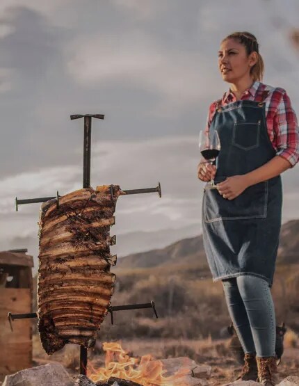 Uma mulher nas montanhas cozinhando carne
