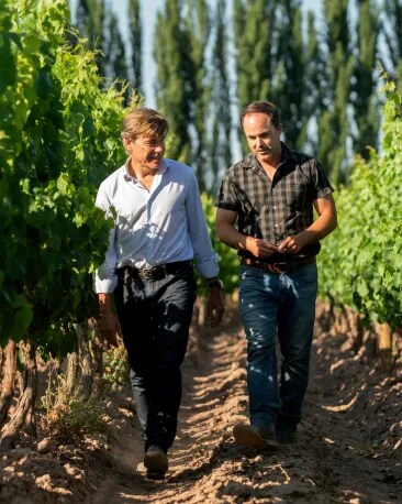 Two winemakers speaking in the middle of high-altitude Terrazas de los Andes Malbec vineyards in Mendoza